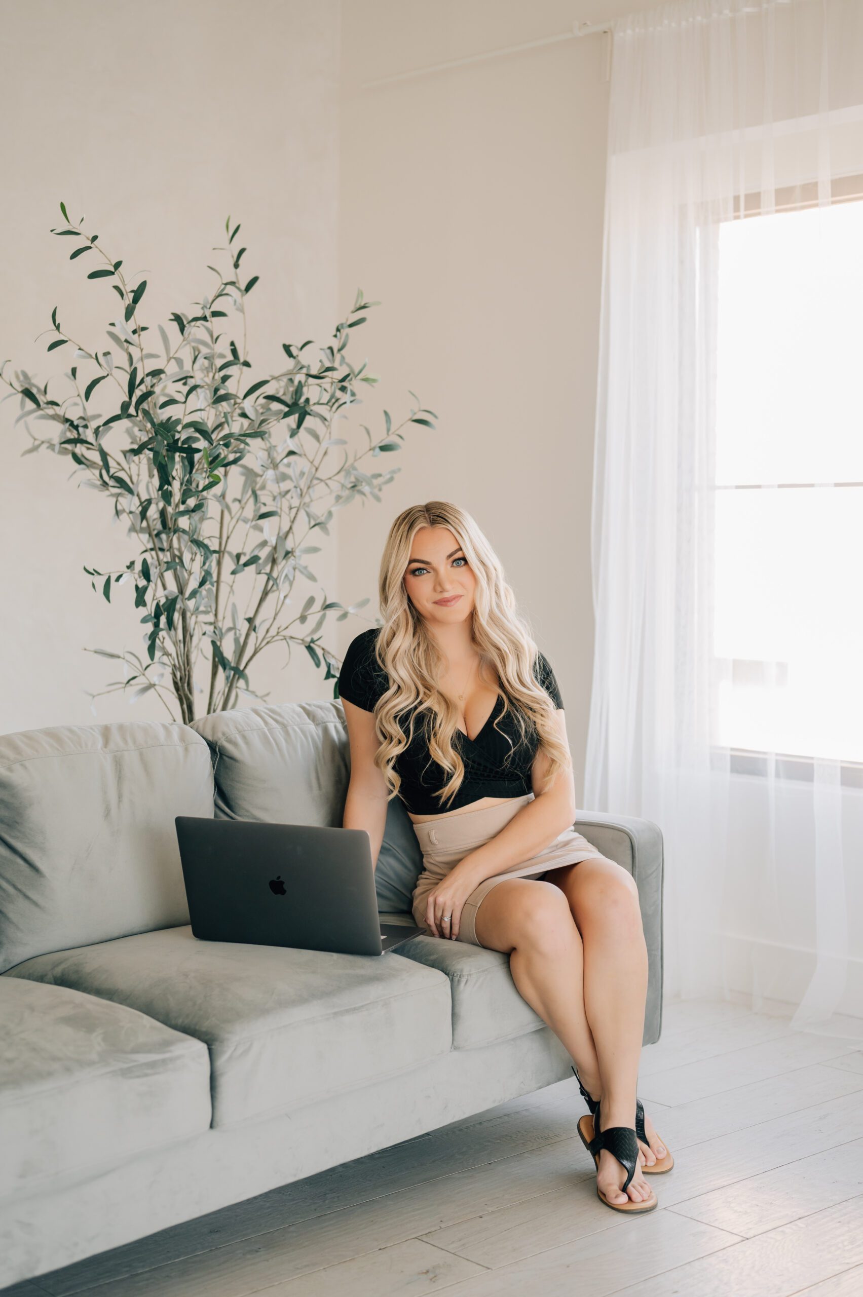 Jackie Siggard wedding photographer in Utah sitting on couch with laptop