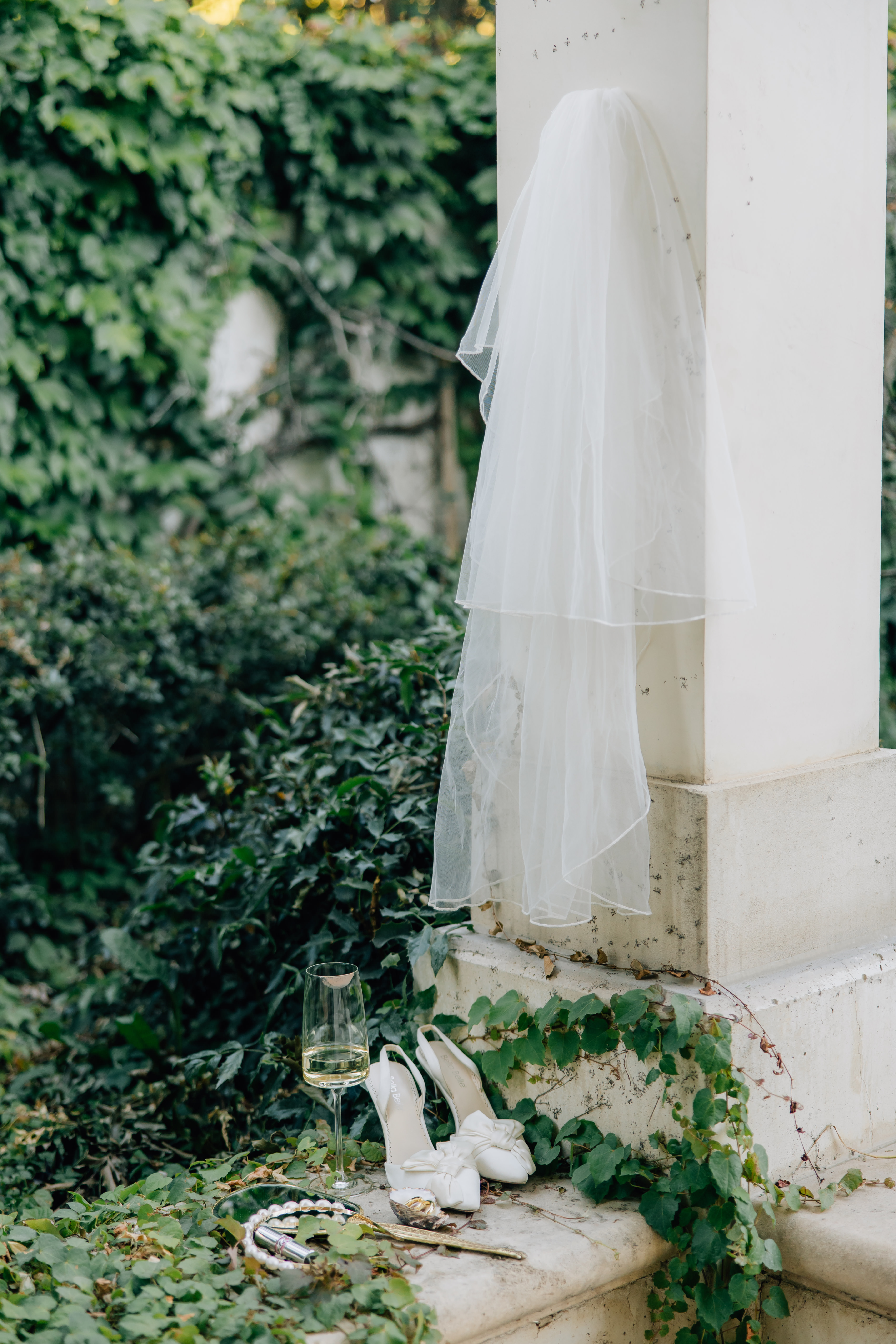 wedding shoes with veil around greenery