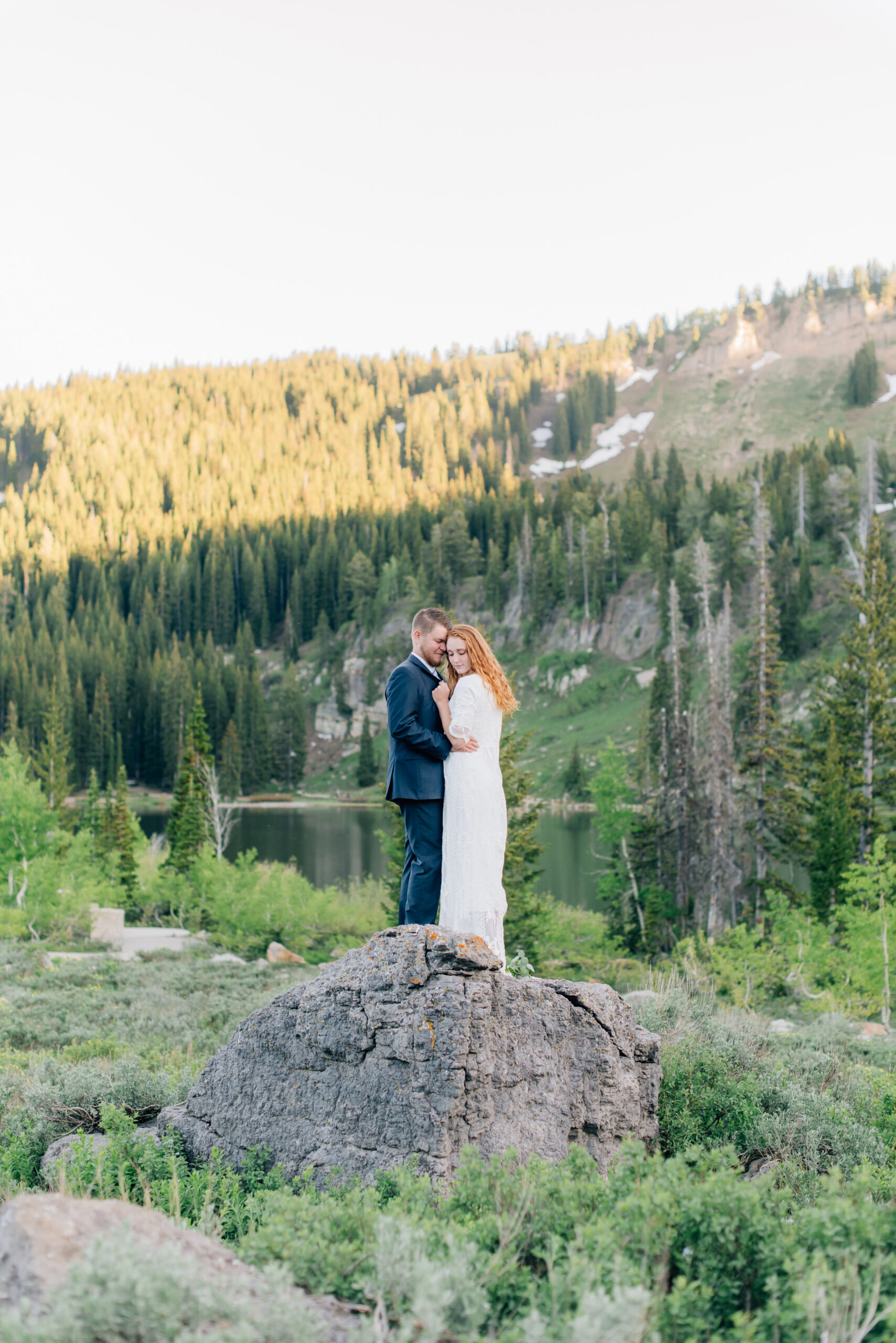 bride and groom standing on a rock at tony grove